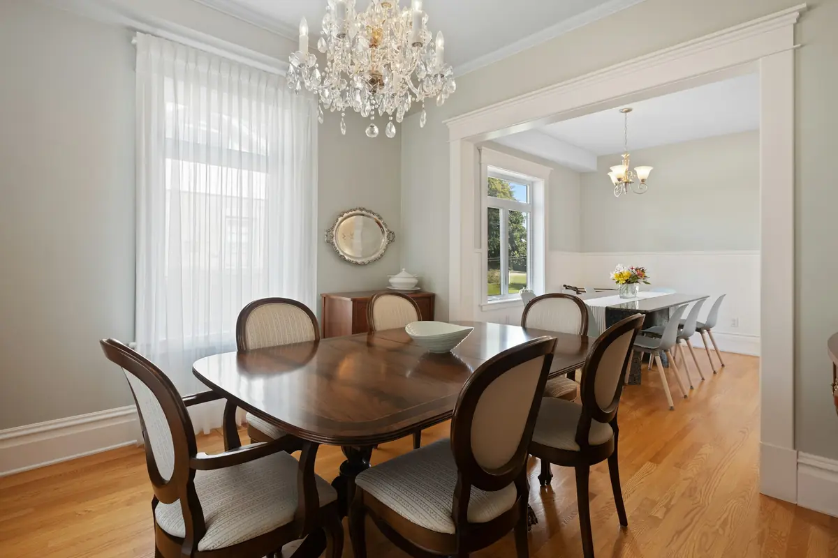 Classic dining room with crystal chandelier, wood table, oval-back chairs and wide cased doorway
